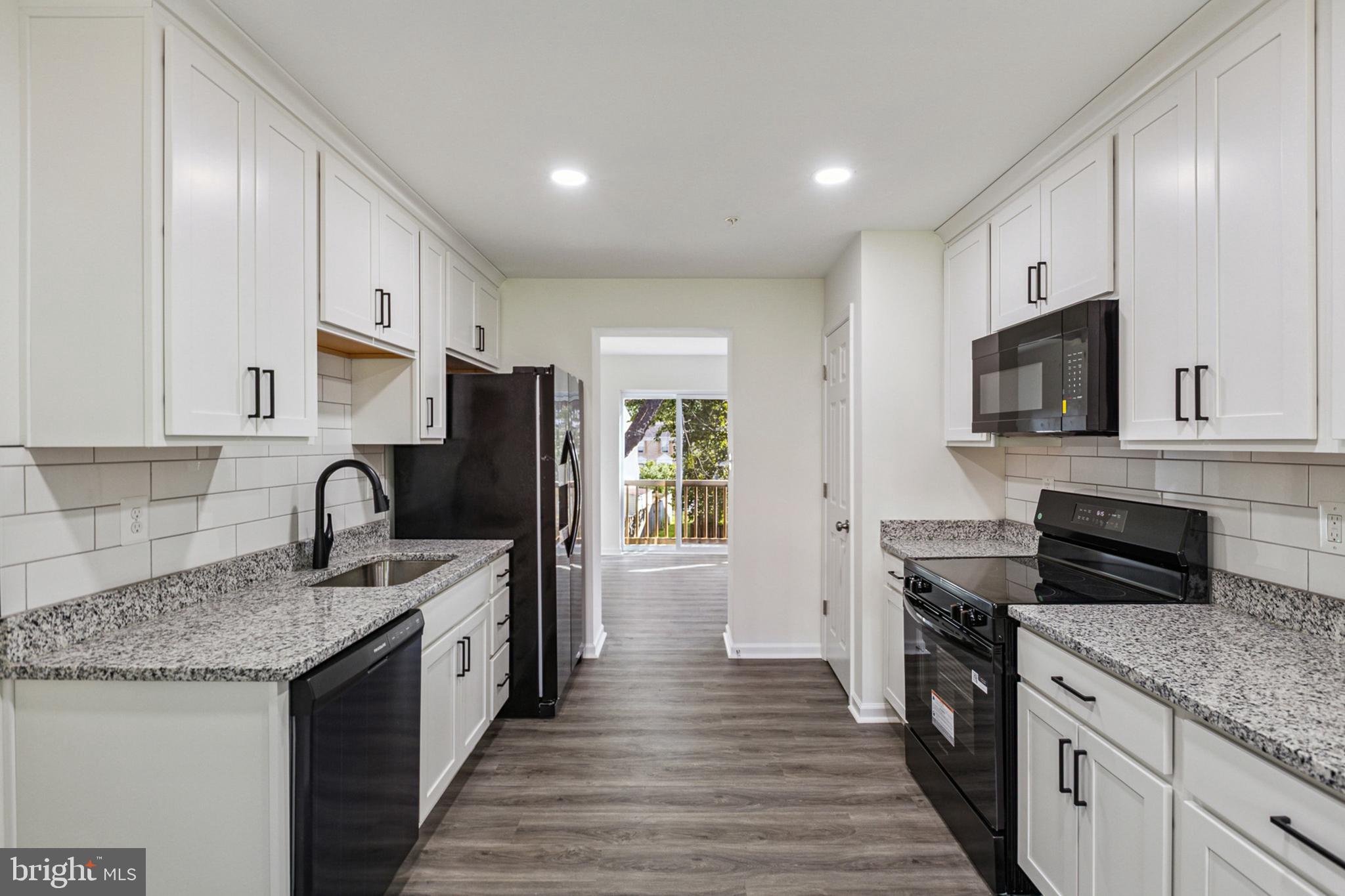 20209 Thunderhead Way Germantown, MD 20874 - Photo 8 of 26 a kitchen with granite countertop a sink dishwasher stove and oven with wooden floor