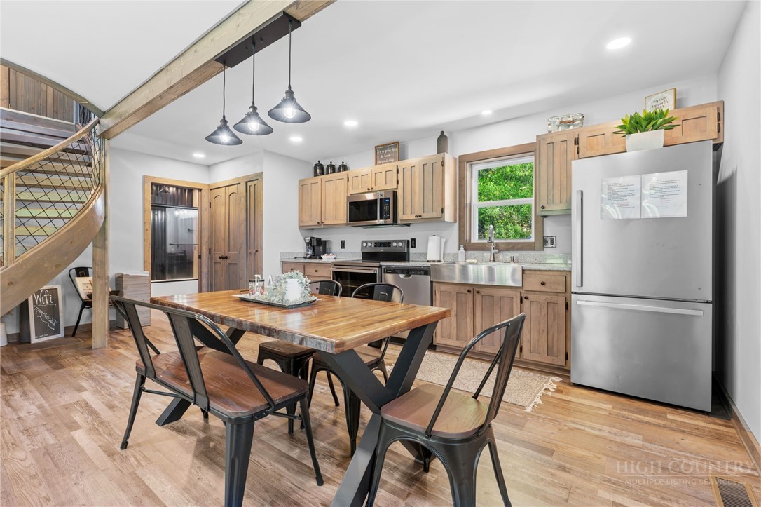 634-636 Watauga River Road Sugar Grove, NC 28679 - Photo 41 of 50 a kitchen with stainless steel appliances a dining table chairs refrigerator and microwave