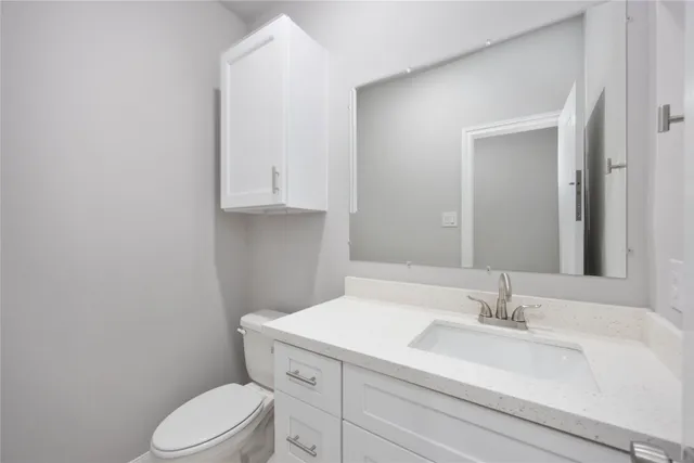a bathroom with a sink a toilet and vanity