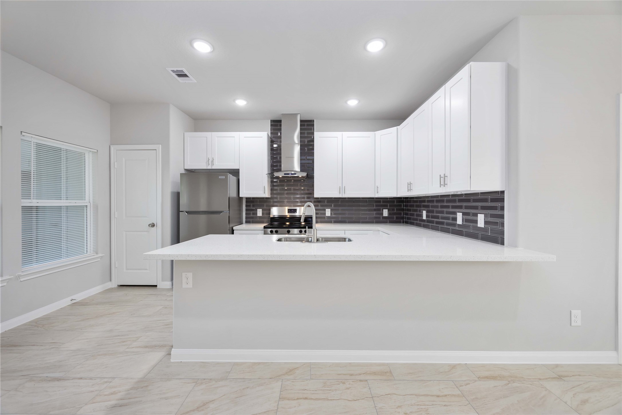 7987 Chateau Street, Unit A Houston, TX 77028 - Photo 8 of 24 a view of kitchen with stainless steel appliances granite countertop a refrigerator a stove a sink and white cabinets with wooden floor