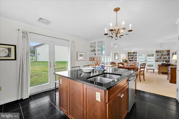 a kitchen that has a lot of cabinets and couches with wooden floor