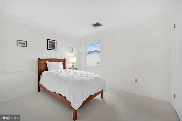 a bedroom with a bed and painting on the wall