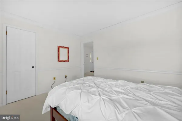 a bedroom with a white bed and a closet