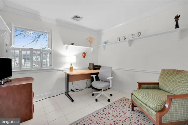 a work room with furniture a rug and a window