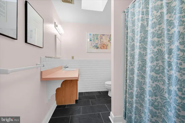 a bathroom with a sink a toilet and mirror