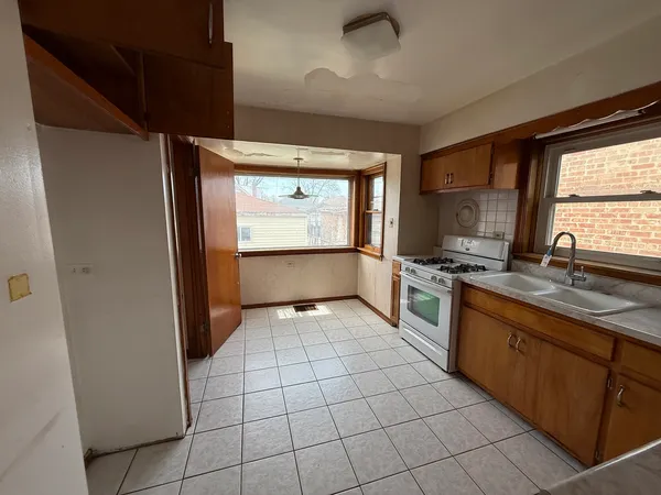 a large kitchen with a stove a sink dishwasher and a refrigerator