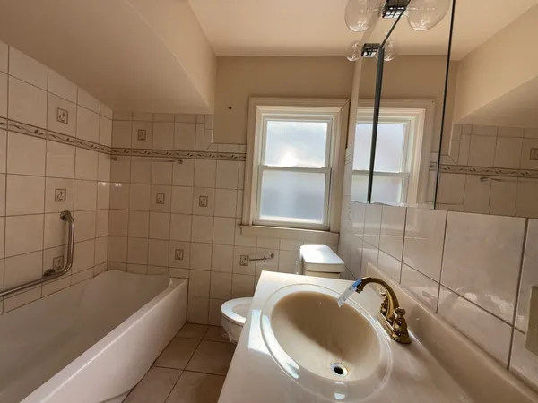 a bathroom with a tub a sink and mirror