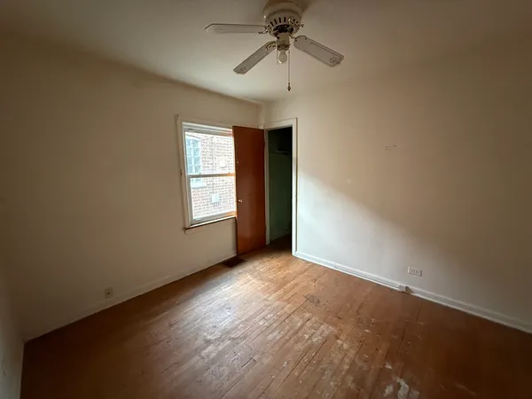 an empty room with windows and fan