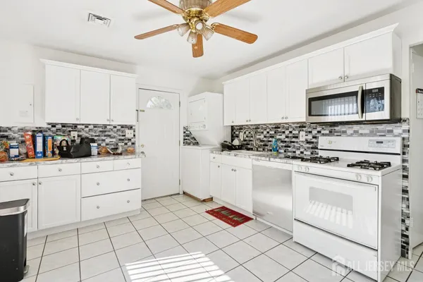 a kitchen with granite countertop a refrigerator sink and cabinets