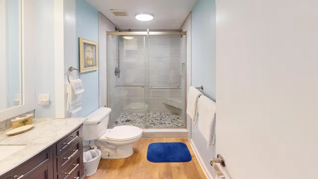 a bathroom with a granite countertop sink toilet and shower