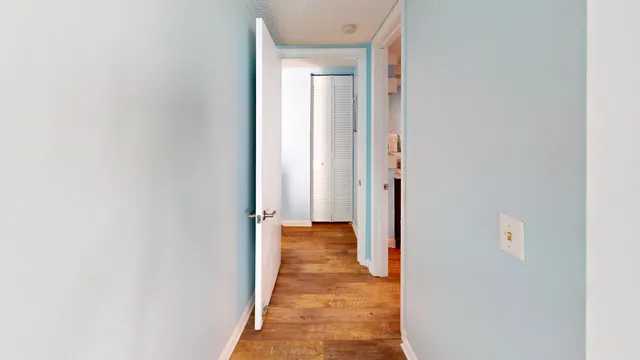 a view of a hallway with wooden floor