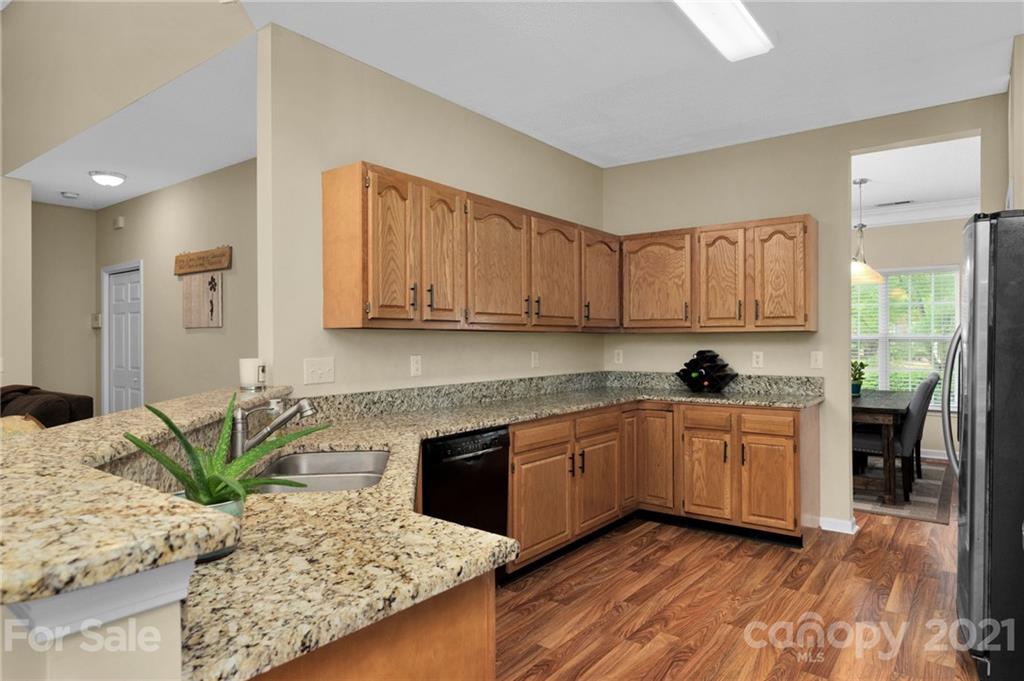 6925 Reedy Creek Road Charlotte, NC 28215 - Photo 15 of 34 a kitchen with granite countertop a stove a sink and a microwave