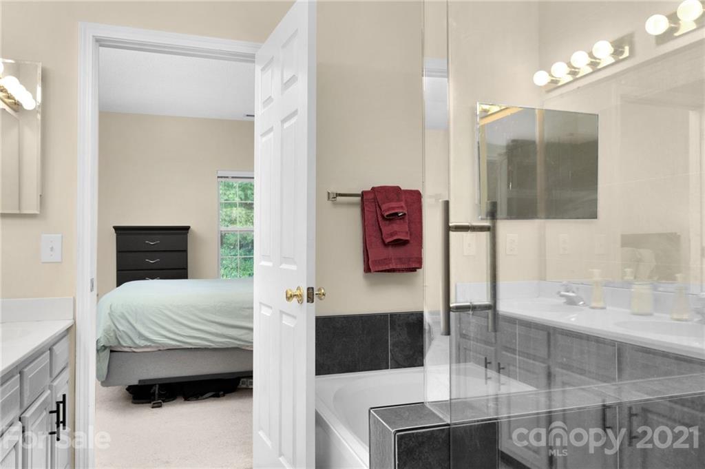 6925 Reedy Creek Road Charlotte, NC 28215 - Photo 22 of 34 a bedroom with a bed a mirror and dresser