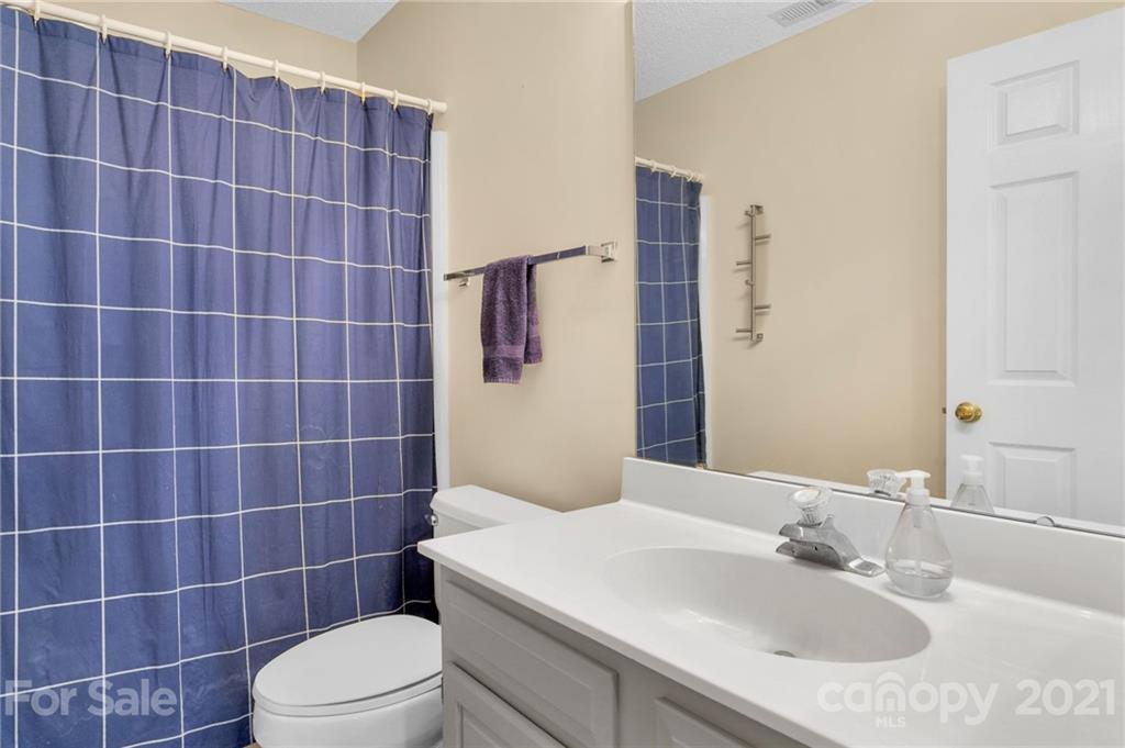 6925 Reedy Creek Road Charlotte, NC 28215 - Photo 24 of 34 a bathroom with a sink a toilet a mirror and shower