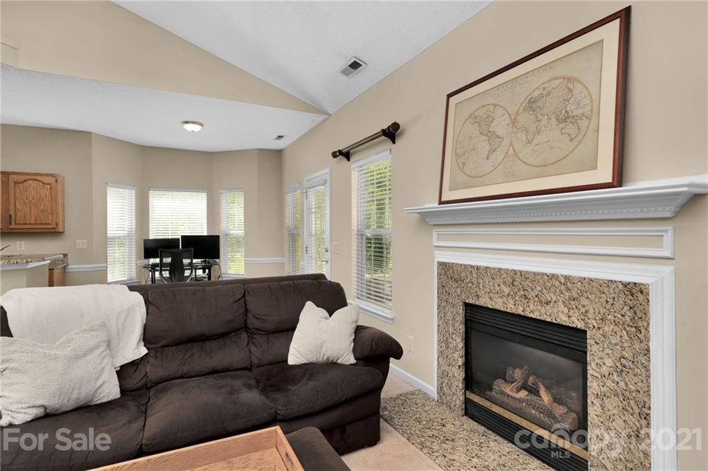 6925 Reedy Creek Road Charlotte, NC 28215 - Photo 10 of 34 a living room with furniture a fireplace and a large mirror