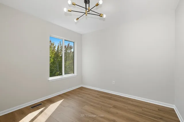 an empty room with a window and a ceiling fan