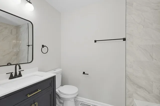 a bathroom with a toilet sink and mirror