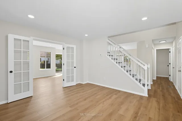 a view of empty room with wooden floor and stairs