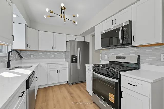 a kitchen with cabinets stainless steel appliances and a sink