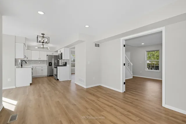 a view of a kitchen with wooden floor and a window