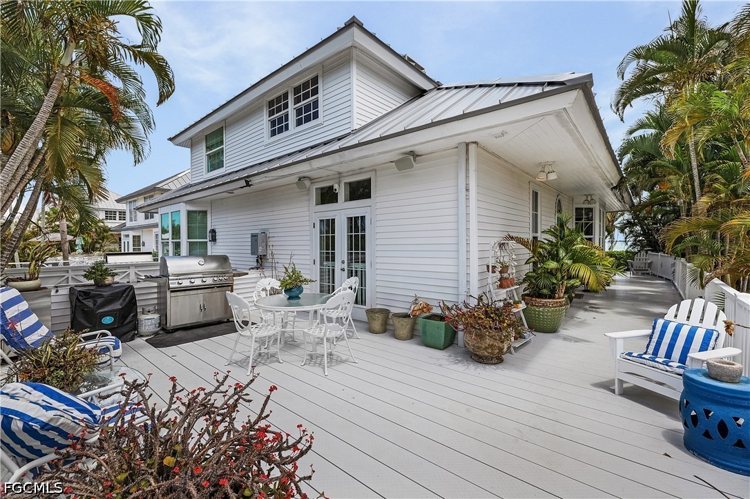515 Useppa Useppa Island Bokeelia, FL 33922 - Photo 36 of 43 a view of a patio with table and chairs potted plants and covered with wooden floor