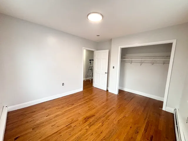 an empty room with wooden floor and closet