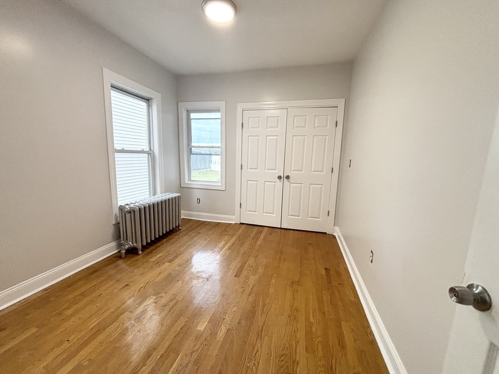 35 Madison Street Malden, MA 02148 - Photo 9 of 16 an empty room with wooden floor and windows