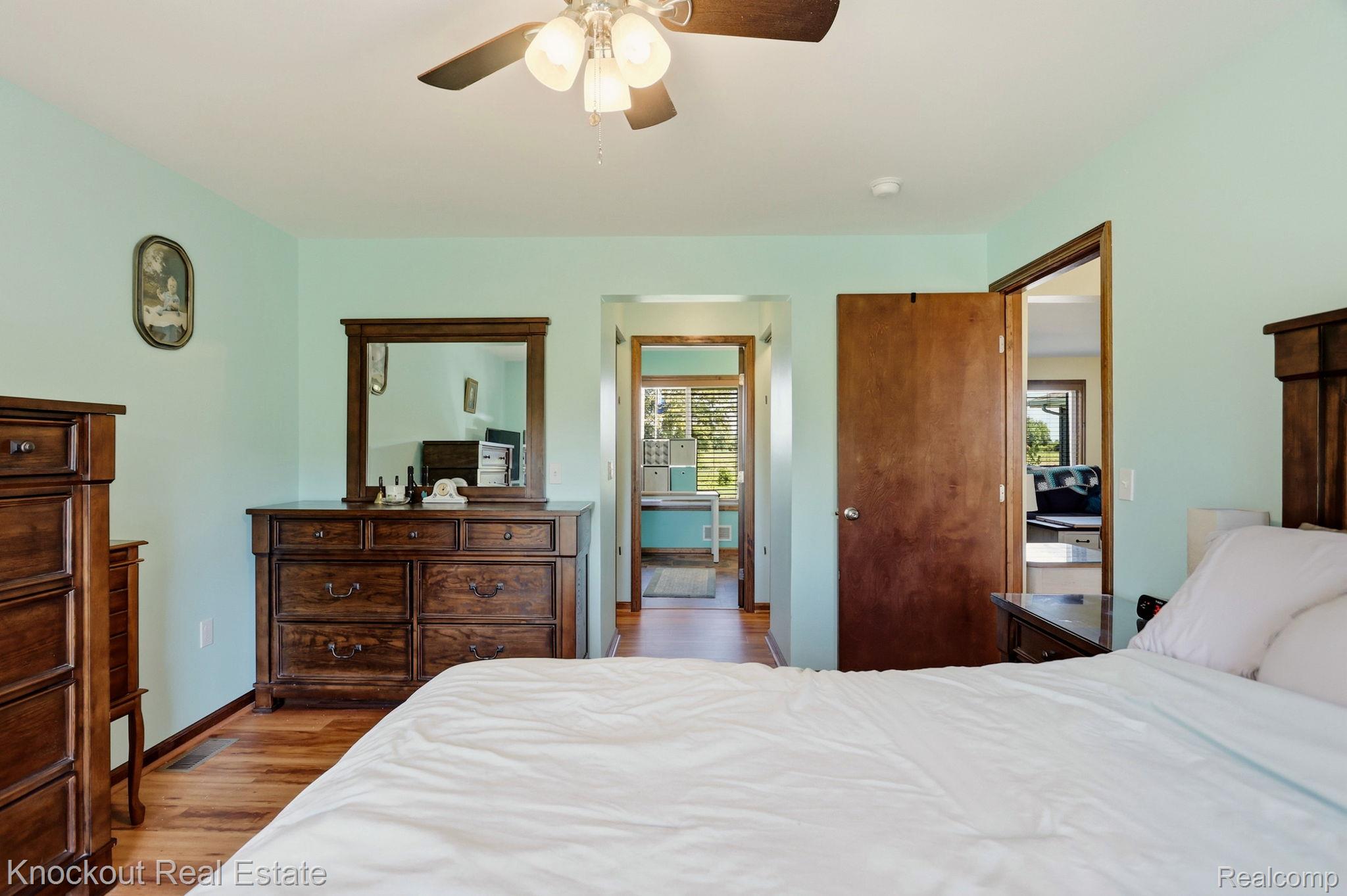 5727 Mackinaw Road Saginaw, MI 48604 - Photo 25 of 60 Wood-finish flooring with light blue wall paint, wood-panel doors, and a ceiling fan with integrated lighting