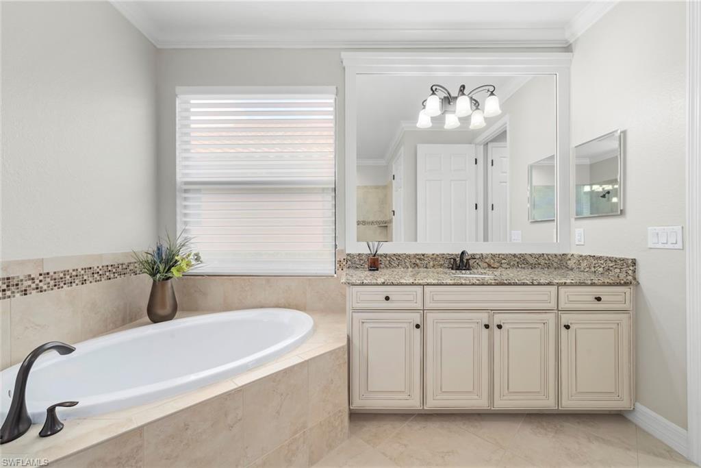 12692 Kinross Lane Naples, FL 34120 - Photo 22 of 47 Soaking tub with bronze-finish fixtures, one of two vanities with granite countertops
