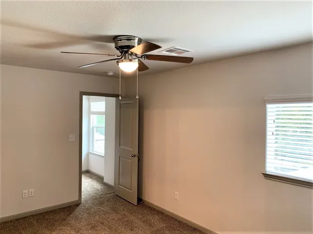 a view of a chandelier fan and window