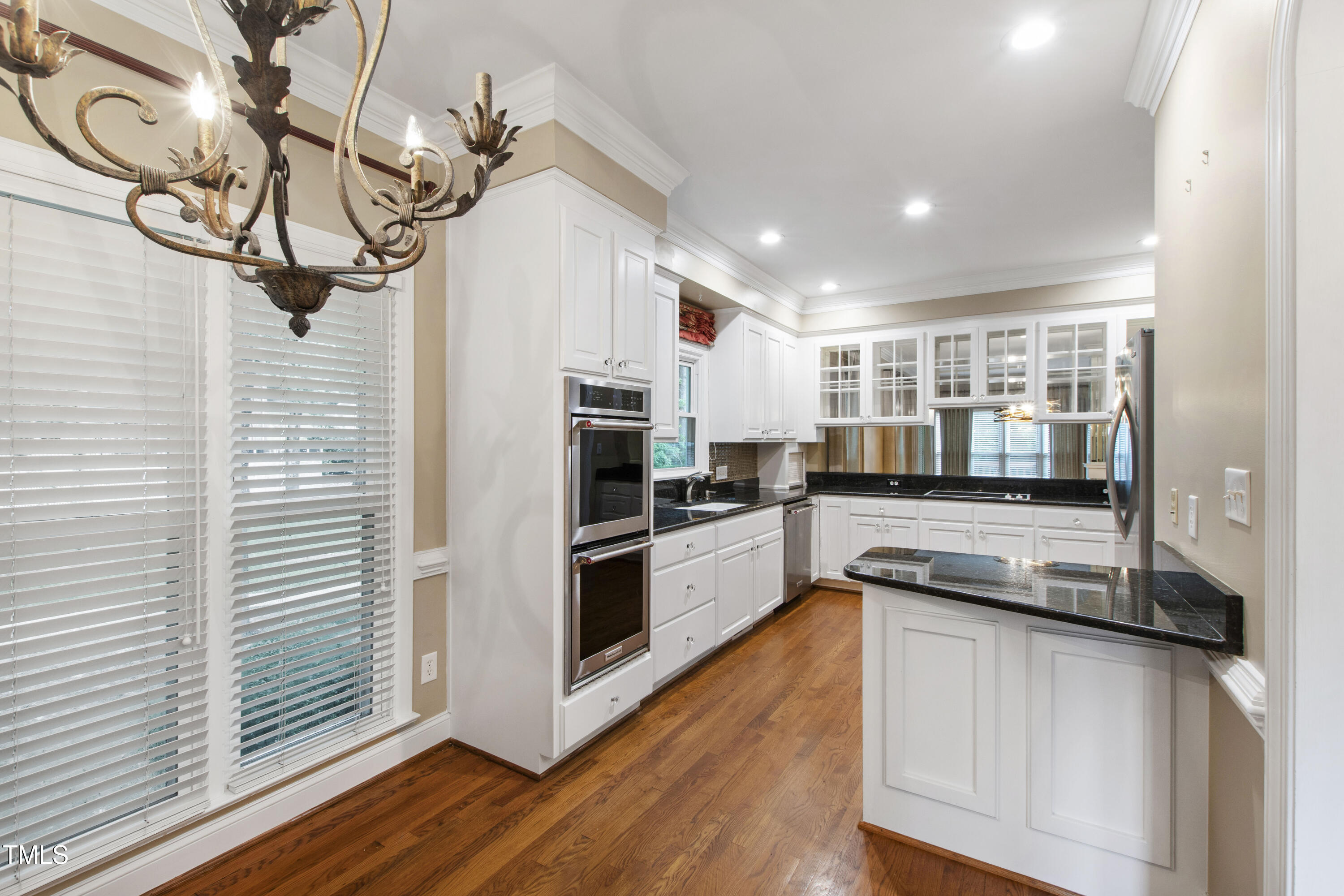 2301 Upper Oaks Way Raleigh, NC 27615 - Photo 12 of 55 a kitchen with stainless steel appliances granite countertop a refrigerator a stove and white cabinets with wooden floor