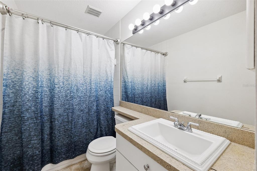 3209 Meta Court Largo, FL 33771 - Photo 13 of 24 a bathroom with a sink a toilet and shower curtain