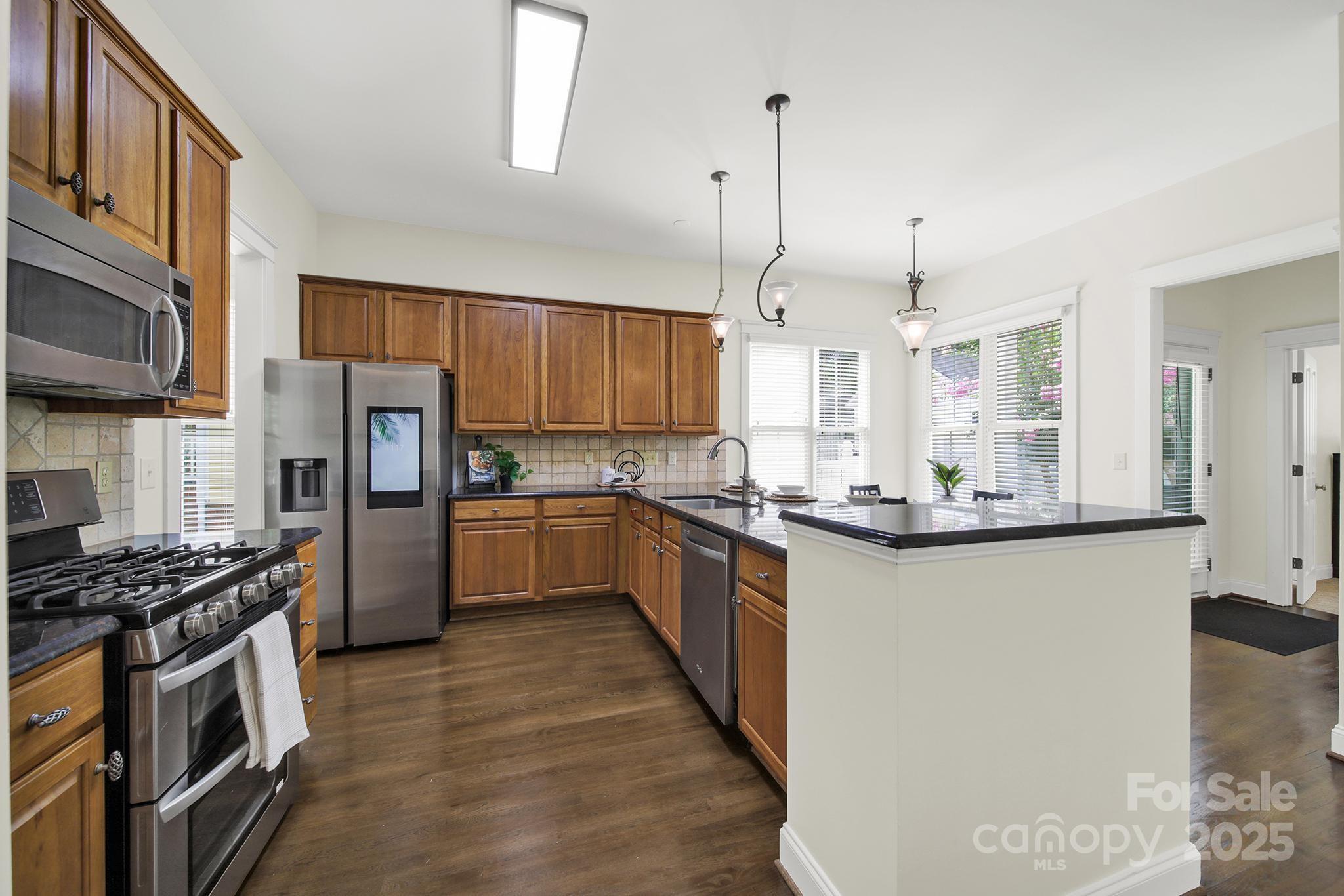 1855 2nd Baxter Crossing Fort Mill, SC 29708 - Photo 10 of 48 a kitchen with stainless steel appliances a refrigerator a stove a sink and a wooden floors