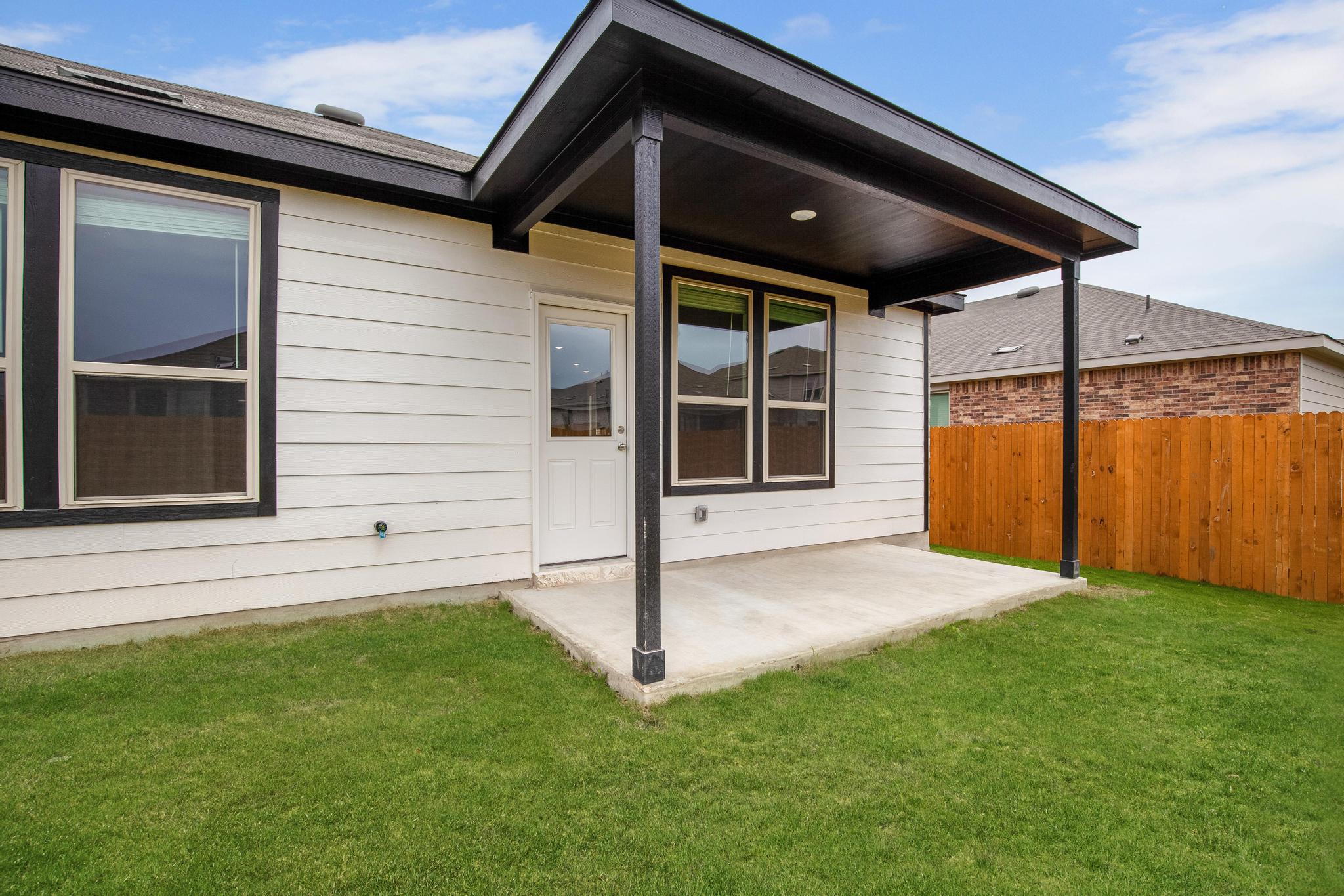 200 Janice Road Taylor, TX 76574 - Photo 23 of 25 A private covered patio extends living space outdoors to a verdant fenced yard.