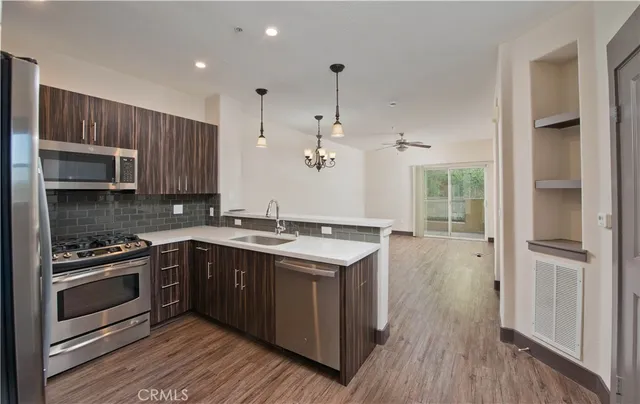 a kitchen with a sink stove and wooden floor