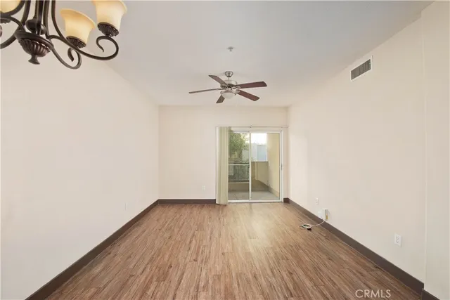 a view of a room with wooden floor and fan