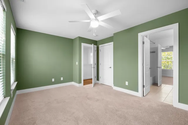 an empty room with a ceiling fan and windows