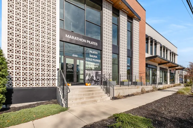 a view of a house with large windows and a small yard
