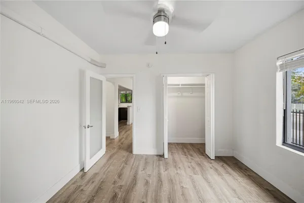 an empty room with closet and windows