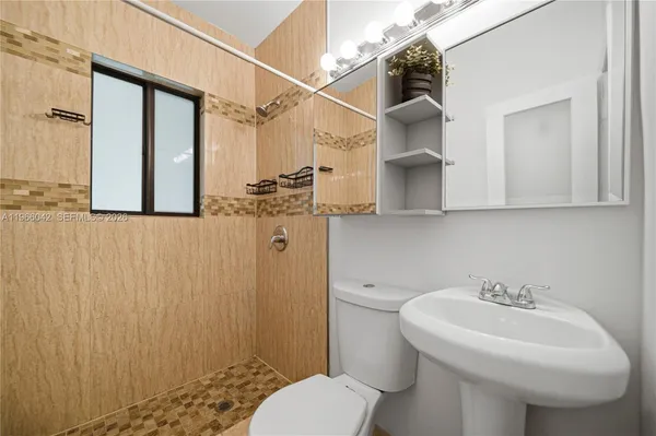 a bathroom with a sink toilet and shower