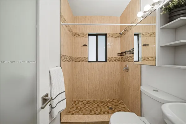 a bathroom with a shower toilet and sink