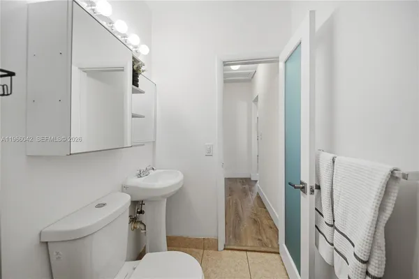 a bathroom with a sink toilet and a mirror
