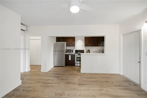 a view of a kitchen with refrigerator and white cabinets