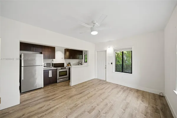 a view of a kitchen with a sink a refrigerator and window