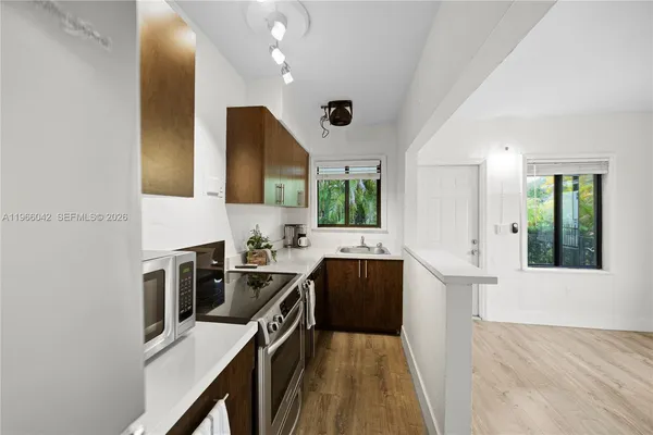 a kitchen with granite countertop a sink stove and cabinets