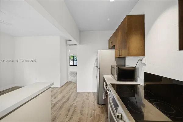 a kitchen with a refrigerator and a stove top oven