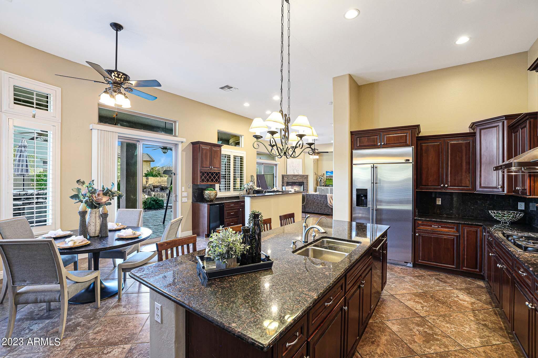 4935 West Yearling Road Phoenix, AZ 85083 - Photo 3 of 57 a kitchen with granite countertop kitchen island stainless steel appliances a dining table and chairs