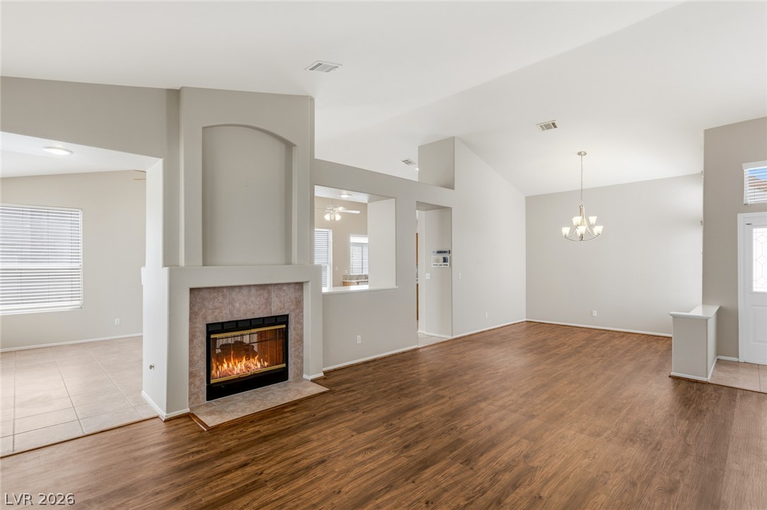9034 Ridgepointe Way Henderson, NV 89074 - Photo 18 of 56 Rich wood flooring anchors this open living space featuring a tiled fireplace and vaulted ceilings.