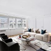 a living room with furniture potted plant and a large window