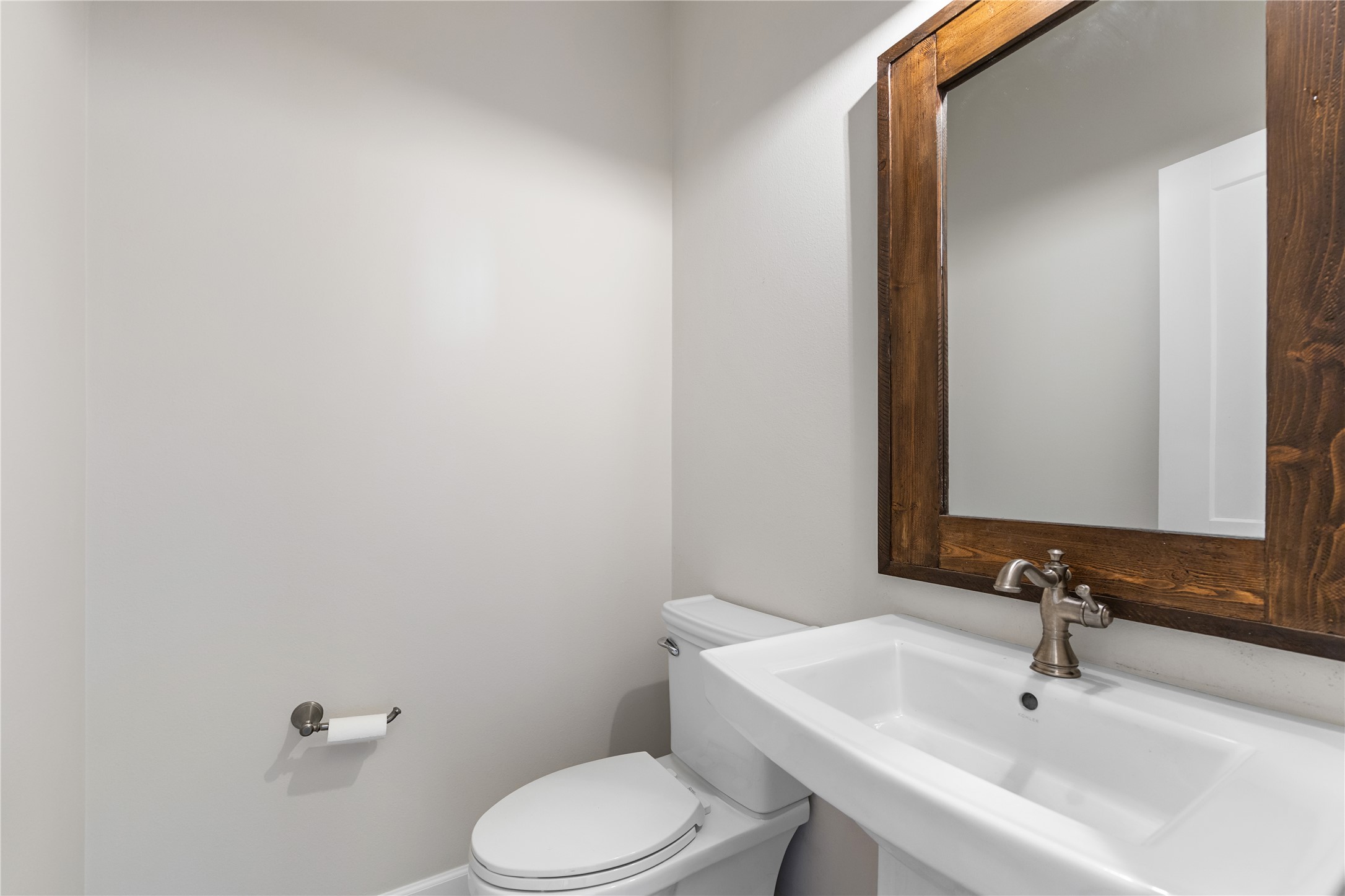 1017 Westland Ridge Road Dripping Springs, TX 78620 - Photo 25 of 40 Clean lines and a wood-framed mirror highlight this minimalist half bath.